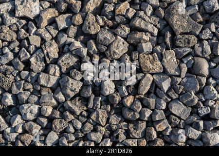 gray texture from pieces of lstones in a pile on the street. Dark gray Pattern of pebbles. Abstract Background Texture of many stones. Filled full fra Stock Photo