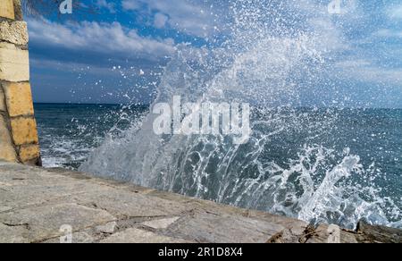 Sea waves beat on the rocks of the shore and scatter in different directions Stock Photo