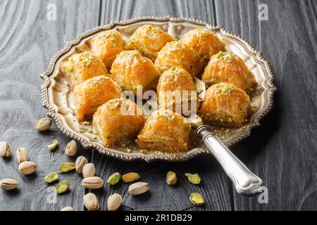 Turkish traditional delight baklava with pistachio on a dark wood background closeup. Horizontal Stock Photo