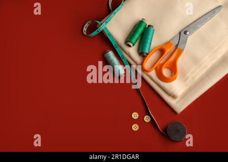 Top view aerial image of a tailor's work desk in a sewing workshop on a bright red background at home office desk studio Stock Photo