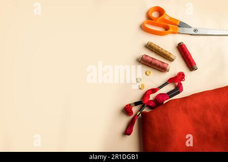 Top view aerial image of a tailor's work desk in a sewing workshop on a bright cream background at home office desk studio Stock Photo