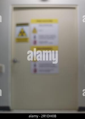 Xray room door with warning signs blurred background Stock Photo