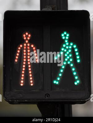 Red and green pedestrian crossing lights on a Paris street, featuring distinctive French walking and stop signals. Stock Photo