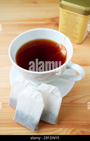 Cup of hot tea with teabags on a wooden table Stock Photo