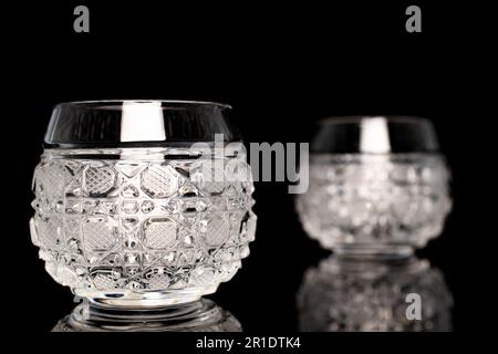 Two crystal glasses, macro, isolated on black background. Stock Photo