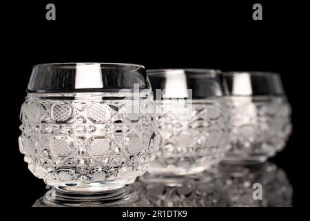 Three crystal glasses, macro, isolated on black background. Stock Photo