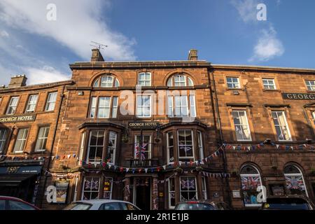 Flags decorating a building to celebrate the coronation of King Charles III, in Penrith, Cumbria, UK Stock Photo