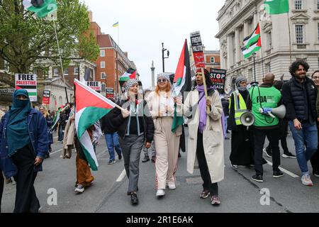 London, UK. 13th May, 2023. Protesters hold placards and flags during a march and rally in central London to commemorate the 75th anniversary of the Nakba day, also known as the Palestinian Catastrophe. Nakba was the process of, what they consider to be, 'ethnic cleansing, colonisation and dispossession which saw over 750,000 Palestinians driven into exile. Credit: SOPA Images Limited/Alamy Live News Stock Photo