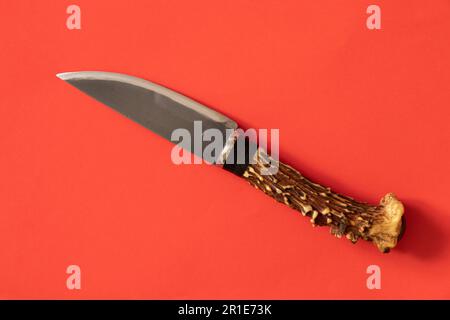 knife with a handle of a deer antler on an isolated background Stock Photo