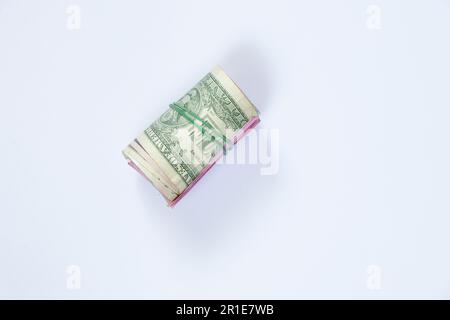 dollars into a roll on an isolated background Stock Photo