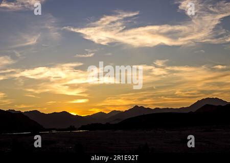 Golden Sunset with the Richtersveld Mountains in Silhouette, along the Orange River in South Africa Stock Photo