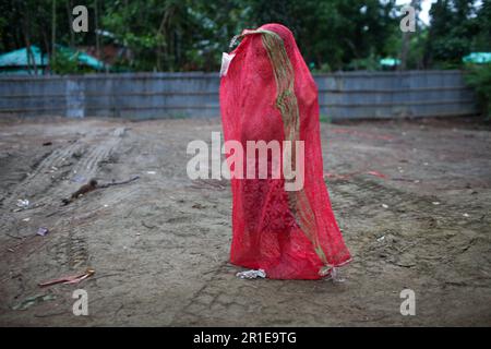 Dhaka, Bangladesh. 13th May, 2023. A child wears a plastic bag to protect himself from the rain in Shah Pari Island area Teknaf, Bangladesh. The maritime port in Cox's Bazar and Shahpori Island has been asked to hoist cautionary signal to 10 as Cyclone Mocha has intensified into an extremely severe cyclonic storm over the east central Bay of Bengal and set to make landfall the 14th. (Credit Image: © Abu Sufian Jewel/ZUMA Press Wire) EDITORIAL USAGE ONLY! Not for Commercial USAGE! Stock Photo