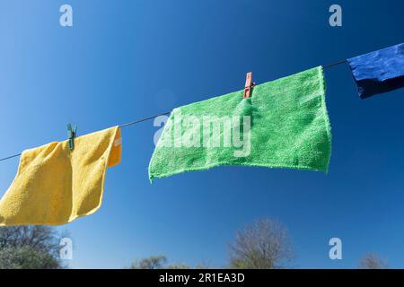 Clothes peg on a towel and washing line against a blue sky Stock Photo