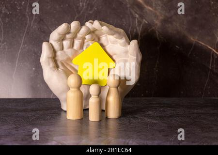 Hands with cut out paper silhouette on table. Family care concept Stock Photo