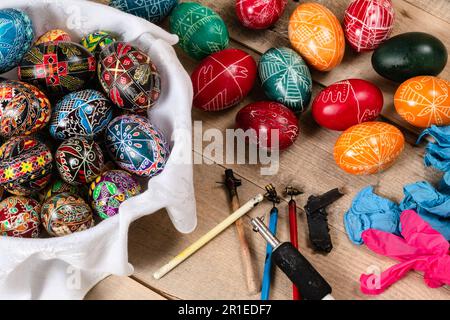 Hand painted painted Easter eggs and decorating materials for making Easter eggs. Painting Easter eggs with hot wax. Stock Photo