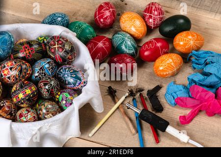 Hand painted painted Easter eggs and decorating materials for making Easter eggs. Painting Easter eggs with hot wax. Stock Photo