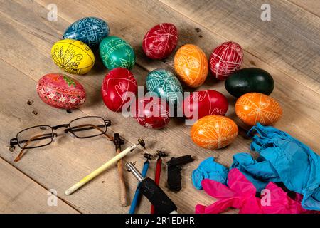 Hand painted painted Easter eggs and decorating materials for making Easter eggs. Painting Easter eggs with hot wax. Stock Photo