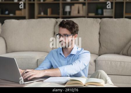 Serious young adult student man studying at home Stock Photo