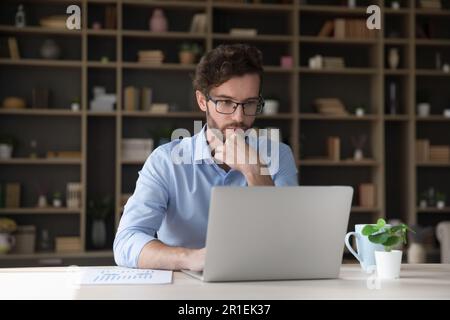 Focused young businessman working at laptop computer Stock Photo
