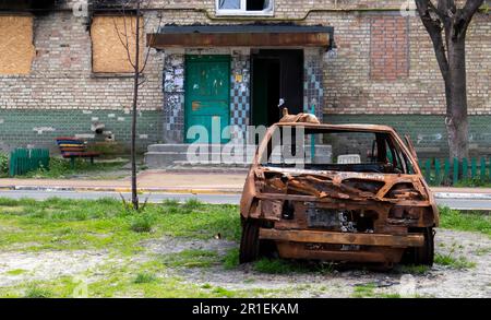 Consequences of the bombing in the city. The rocket blew up the house. A bombed-out apartment building and burnt-out cars after an airstrike. Holes in Stock Photo