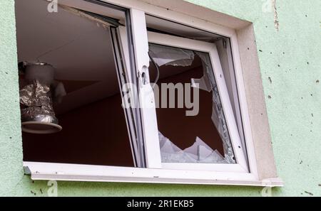 Destroyed and damaged window in the building as a result of the war. The houses were destroyed and burned by artillery during the war. Broken windows. Stock Photo