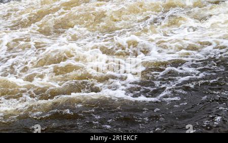 River rapids. Close up abstract background of falling water. Water flows over river rocks. A beautiful powerful stream of a stormy mountain river. The Stock Photo
