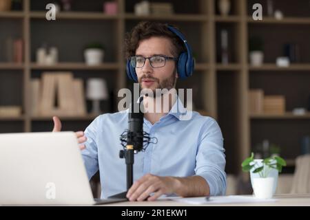 Serious handsome young businessman using wireless headphones Stock Photo