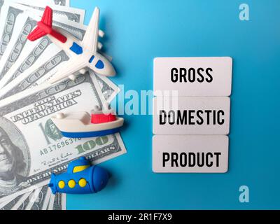 Toys and banknotes with the word GROSS DOMESTIC PRODUCT on blue background Stock Photo