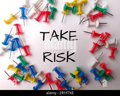Colorful push pin with the word TAKE RISK on white background Stock Photo