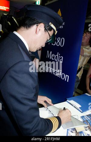 Captain Robert Ting, pilot of the first commercial Singapore Airlines A380 flight, between Singapore and Sydney, autographs model aircraft wings in the Arrivals Lounge of Sydney (Kingsford Smith) Airport. Sydney, Australia. 25.10.07. Stock Photo