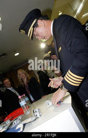 Captain Robert Ting, pilot of the first commercial Singapore Airlines A380 flight, between Singapore and Sydney, autographs model aircraft wings in the Arrivals Lounge of Sydney (Kingsford Smith) Airport. Sydney, Australia. 25.10.07. Stock Photo