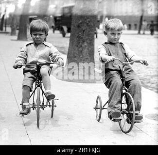 Archival Photo: Children having fun riding on tricycles ca. 1910s or 1920s Stock Photo