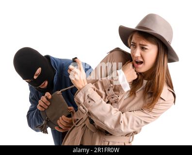 Young woman with pepper spray defending herself against thief on white background Stock Photo