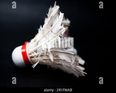 Picture of a broken shuttlecock on a black isolated background Stock Photo