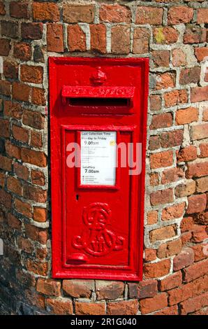 Edward VII red post box in old brick wall. Cypher of old red post box Stock Photo