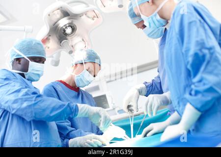 Leave it to the professionals. Diverse group of surgeons working together as a team in an operating theatre. Stock Photo