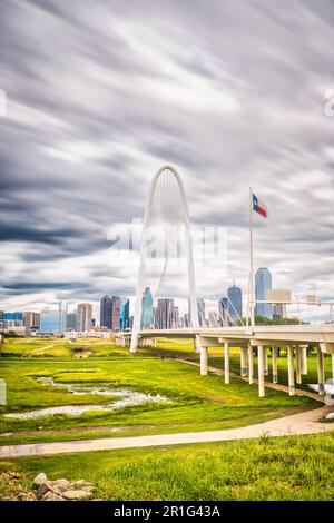 The Margaret Hunt Hill Bridge in Dallas, Texas stands as a stunning landmark amidst the cityscape, its long exposure and clouds contrasting against Stock Photo