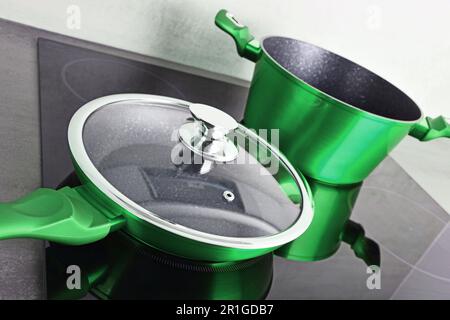 Frying pan and steel pot on modern induction cooktop Stock Photo