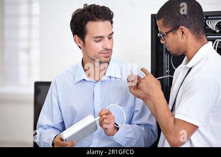 Businessman, technician and server room discussion with an engineer to explain cable management. Network router, database and a young male system Stock Photo