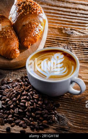 Composition with a cup of coffee and two croissants on an old wooden table Stock Photo