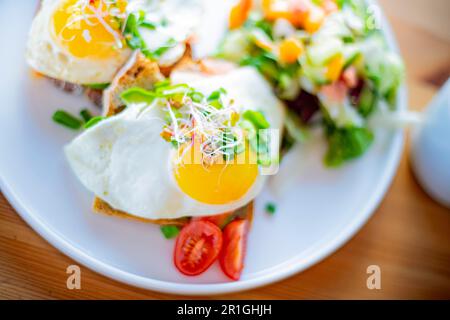 Breakfast with fried eggs on toasts on a restaurant table Stock Photo