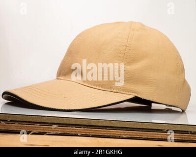 Brown baseball hat on a white wooden table Stock Photo