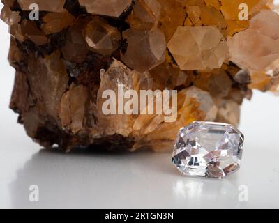 Sparkling asscher cut diamond with rough citrine stone background Stock Photo