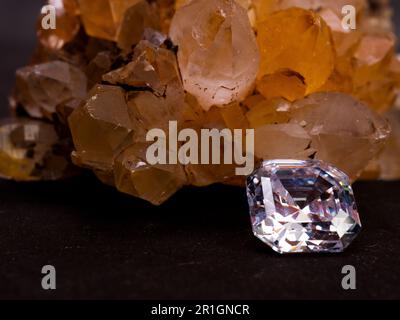 Sparkling asscher cut diamond with rough citrine stone as background Stock Photo
