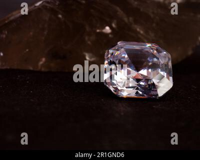 Beautiful and sparkling asscher cut diamond with rough stone background Stock Photo