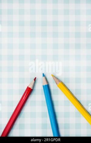 blue red and yellow pencils on a geometric background Stock Photo