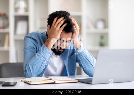 Stressed Indian Male Freelancer Having Problems With Remote Work Stock Photo