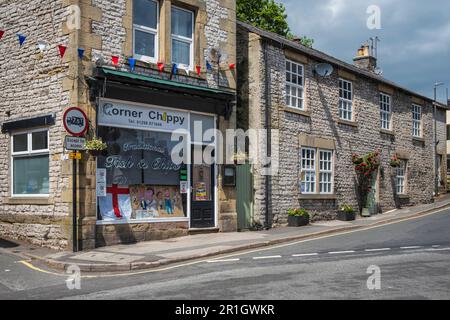 The Corner Chippy fish and chip shop with a window display marking the 75th anniversary of VE Day, Tideswell, Peak District National Park, Derbyshire Stock Photo