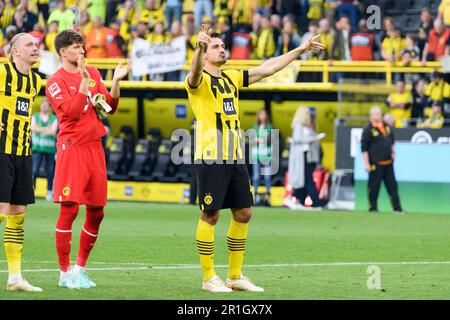 Mats HUMMELS (re., DO), Marius WOLF (li., DO) and goalwart Gregor KOBEL (DO) are happy about the victory after the game in front of the fans of the southern stands, soccer 1. Bundesliga, 32. matchday, Borussia Dortmund ( DO) - Borussia Monchengladbach (MG) 5: 2, on May 13th, 2023 in Dortmund/Germany. Stock Photo