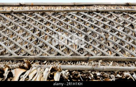 Traditional thai primitive thatch roof made with palm leaves cover by wood frame for hard wind protect. Stock Photo